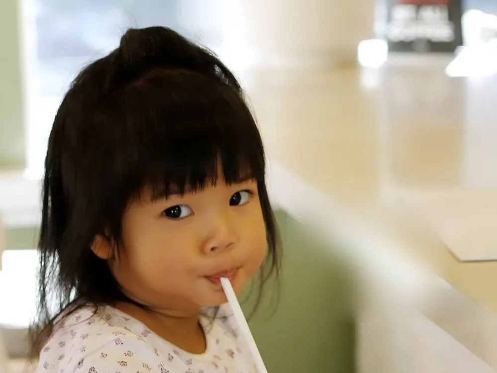 Aurelia at the cafe, drinking through a straw